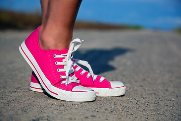 Image showing Pink sneakers on girl, woman legs