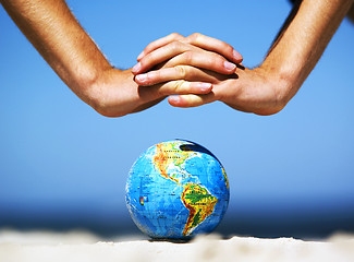 Image showing Earth globe with hands over it. Conceptual image