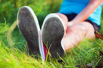 Image showing Pink sneakers on girl legs on grass