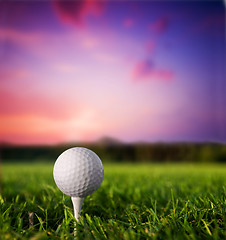 Image showing Golf ball on tee at sunset