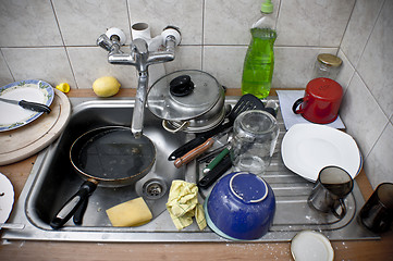 Image showing Pile of dirty dishes in the metal sink