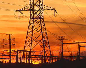Image showing Electricity pylons at orange sunset 