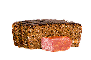 Image showing cut smoked sausage and dark bread grain pieces 