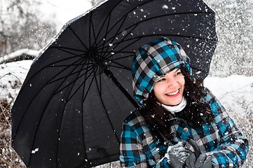 Image showing Young woman with umbrella in a blizzard