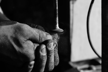 Image showing Hands of a worker polishing metal