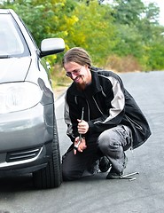 Image showing Handsome young man repairing car