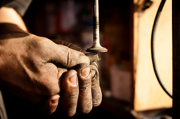 Image showing Hands of a worker polishing metal