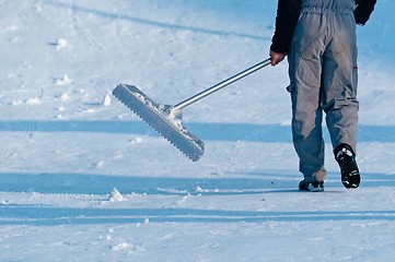 Image showing Male worker cleaning the road from the snow