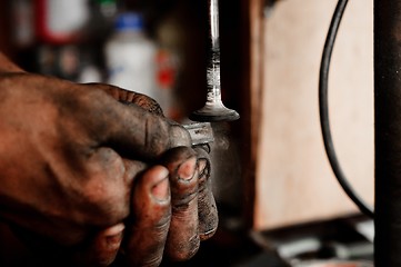 Image showing Hands of a worker polishing metal