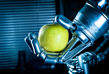 Image showing A robot hand holding a fresh apple