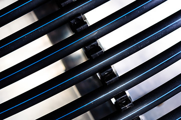 Image showing Black plastic pipes against white background