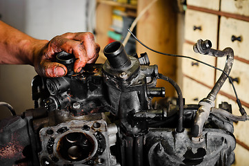 Image showing Worker repairing broken motor