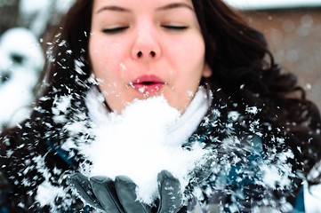 Image showing Woman blewing snow in my face