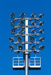 Image showing Stadium lighting with a lot of reflectors against blue sky