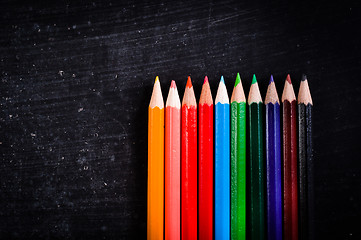 Image showing Colorful pencils against black chalkboard