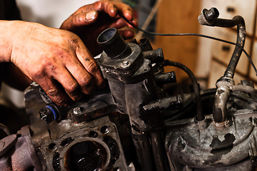 Image showing Hands of a worker repairing broken engine