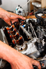 Image showing Hands of a worker repairing broken engine