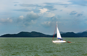 Image showing white sailboat in the background of the tropical islands