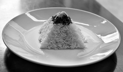 Image showing pyramid of rice on a plate in a restaurant with a worn table