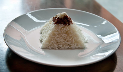 Image showing pyramid of rice on a plate in a restaurant with a worn table