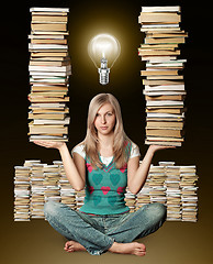 Image showing woman in lotus pose with many books in her hands and bulb