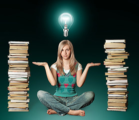 Image showing woman in lotus pose with many books near and bulb