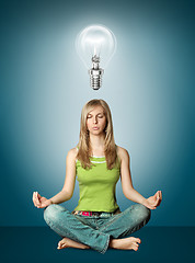 Image showing woman meditation in lotus pose with bulb