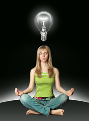 Image showing woman meditation in lotus pose with bulb