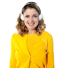 Image showing Smiling young woman listening music in headphones