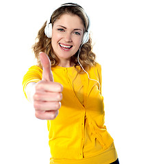 Image showing Thumbs-up woman enjoying music