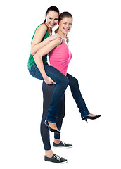 Image showing Teenage girl piggybacks her friend