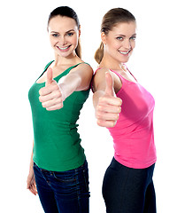 Image showing Smiling pretty girls gesturing thumbs-up