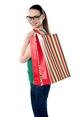 Image showing Side view of woman holding shopping bags