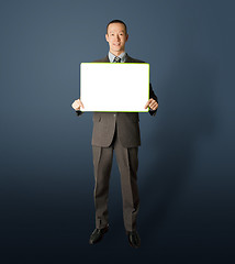 Image showing happy businessman holding blank white card