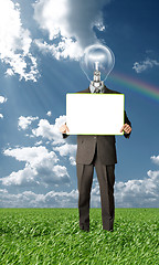 Image showing businessman with lamp-head holding blank card outdoors