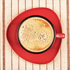 Image showing red coffee cup on striped tablecloth