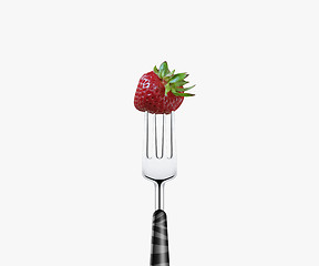 Image showing strawberry  pierced by fork,  isolated on white background 