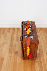 Image showing Leather suitcase with too much clothing