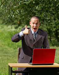 Image showing man with red laptop working outdoors