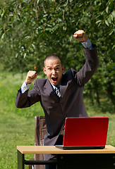 Image showing man with red laptop working outdoors