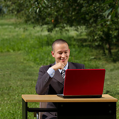 Image showing man with red laptop working outdoors