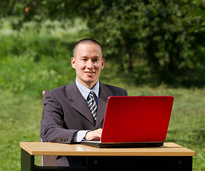 Image showing man with laptop working outdoors