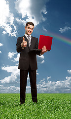 Image showing Full length portrait of male with laptop outdoors