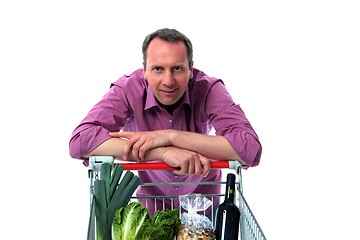 Image showing Man leans on shopping cart