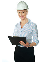 Image showing Smiling female architect holding documents