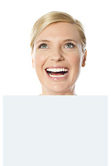 Image showing Thoughtful smiling woman holding whiteboard