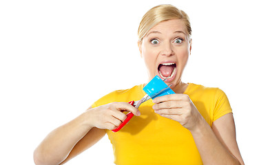 Image showing Excited female cutting her credit card