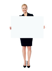 Image showing Female business promoter holding white blank banner ad