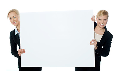 Image showing Female business representatives presenting blank banner ad