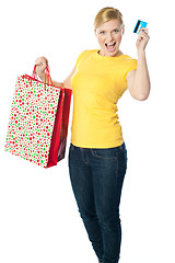 Image showing Happy shopaholic girl showing credit card